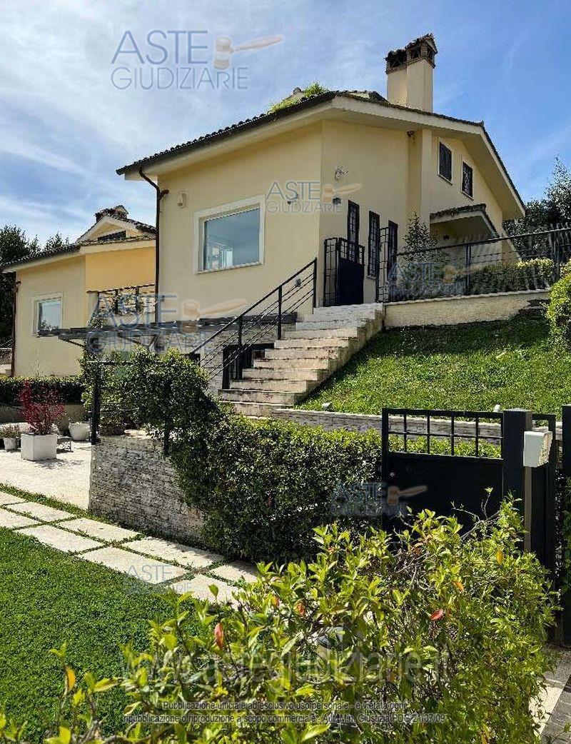 Quota pari a 1/1 del diritto di piena ed intera proprietà di appartamento in villa, sviluppantesi al piano seminterrato e piano primo, con annesso portico e corte di pertinenza, sito nel Comune di Sacrofano, zona Monte Caminetto, alla Via delle Gardenie n